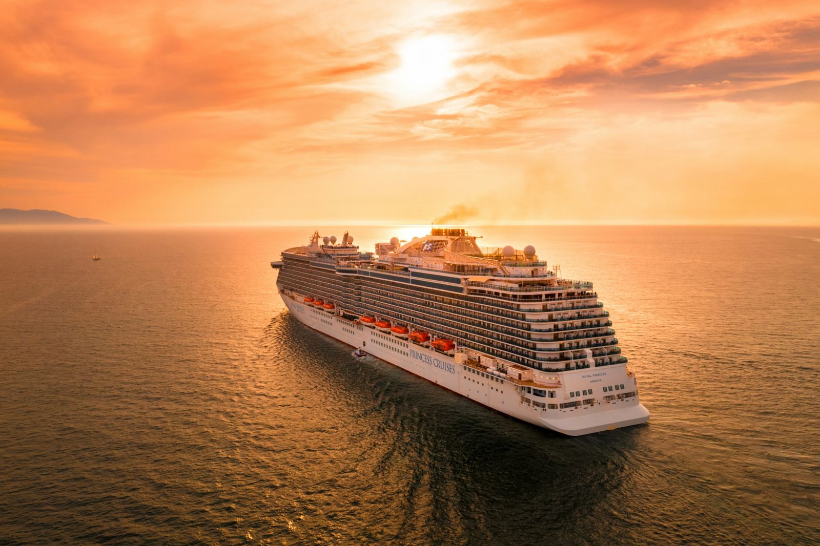 Large ocean cruise ship at sea at sunset